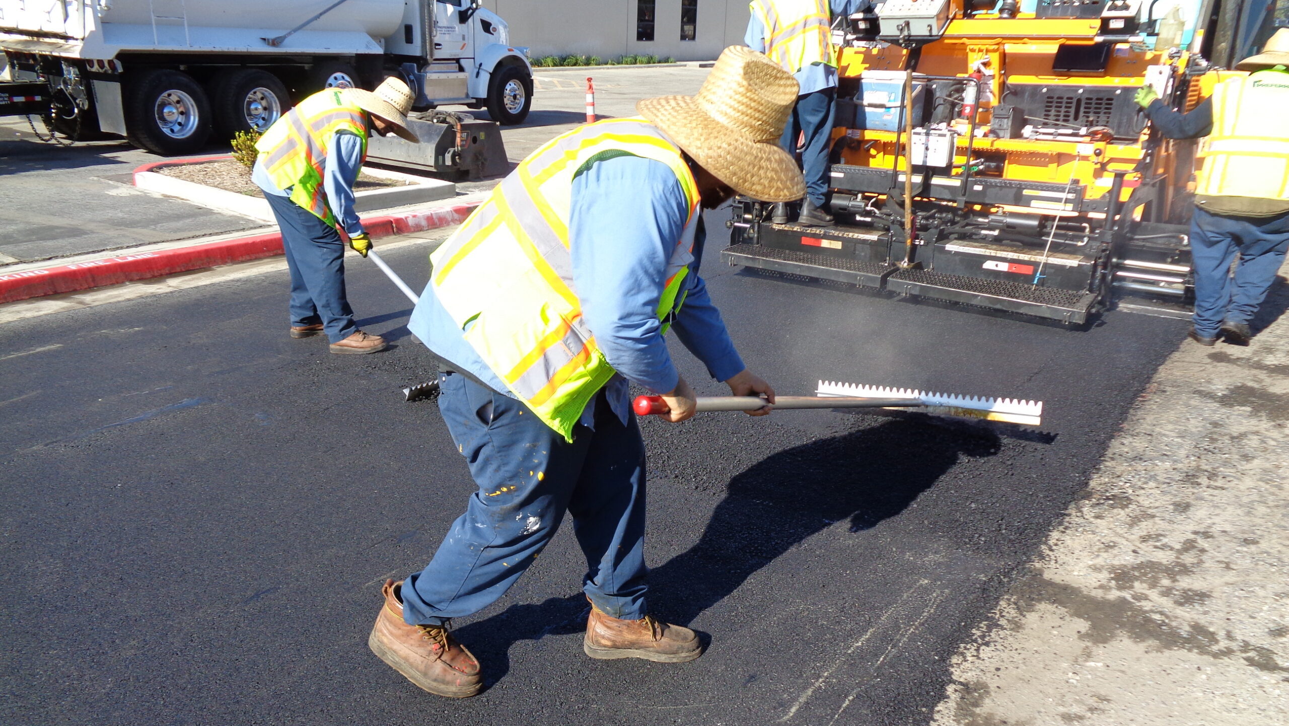 An operator using Surfa Slick's magnesium asphalt lutes to smooth asphalt