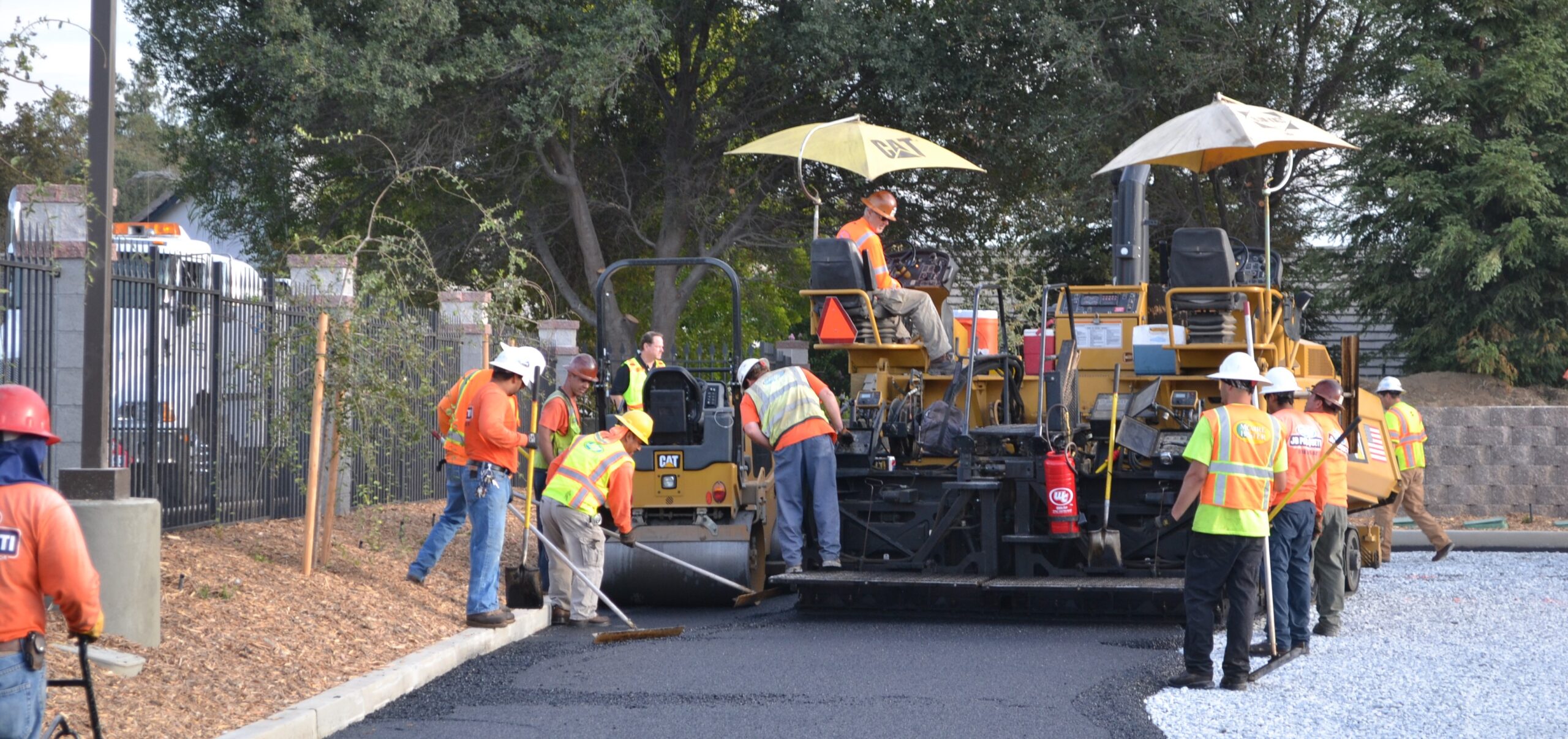 Operators using Surfa Slick's magnesium asphalt lutes to smooth the asphalt surface